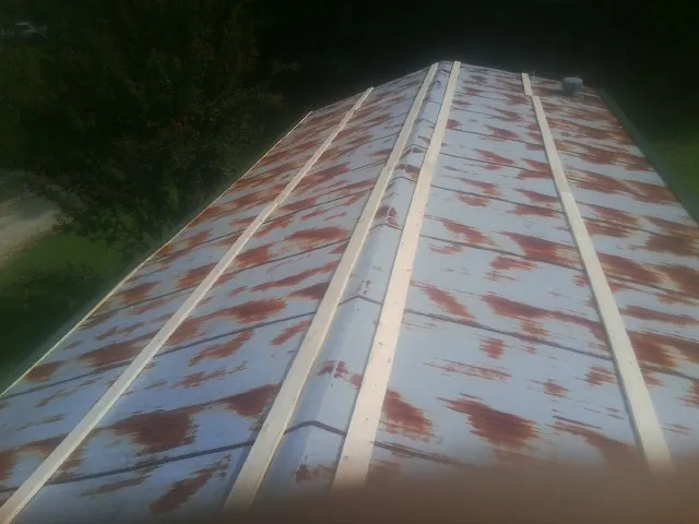 Rusted metal roof panels with new wood purlins before replacement — Storm Damage Roof Repair in Sylvan Beach by Roofing Brothers