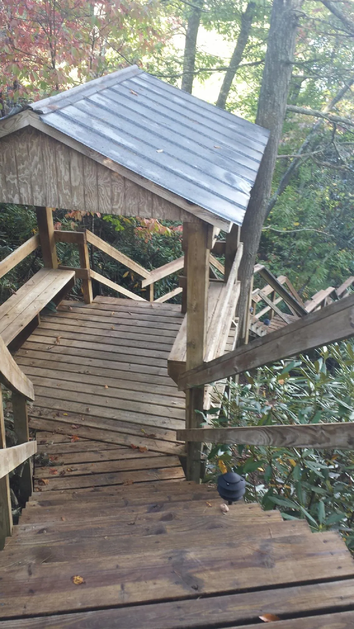 Metal roofed shelter over wooden steps on a wooded walkway — Skylight Repair & Installation work by our crew in Sylvan Beach